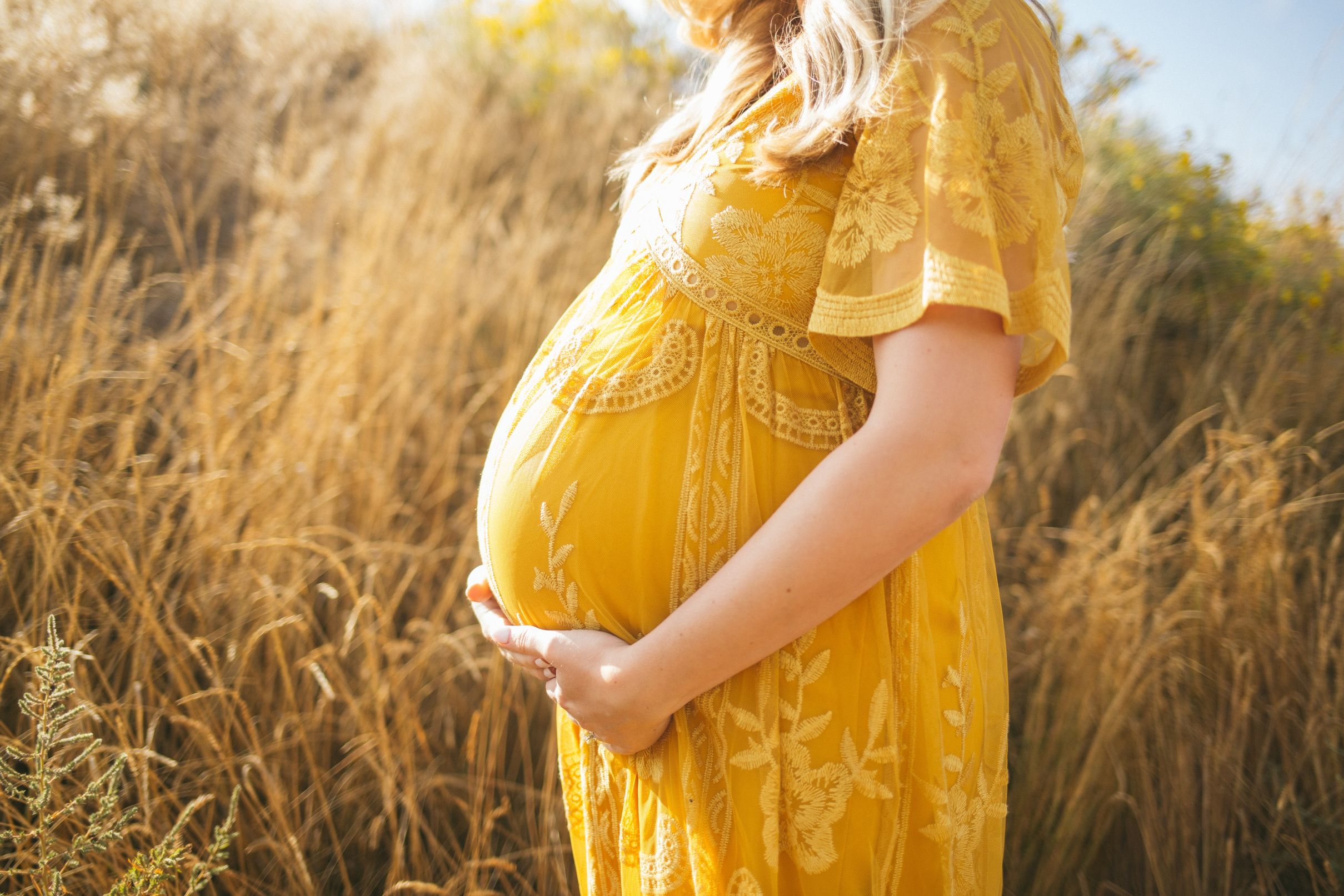 Pregnant woman in yellow dress -- Maven Clinic