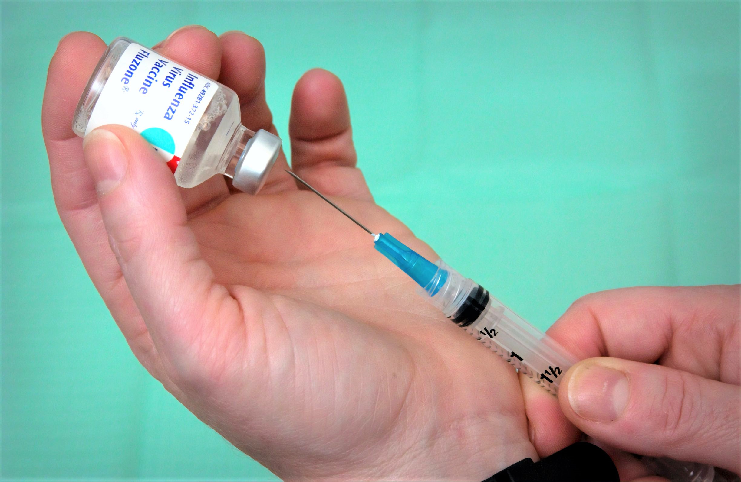 Person holding syringe and vial -- i2O Therapeutics