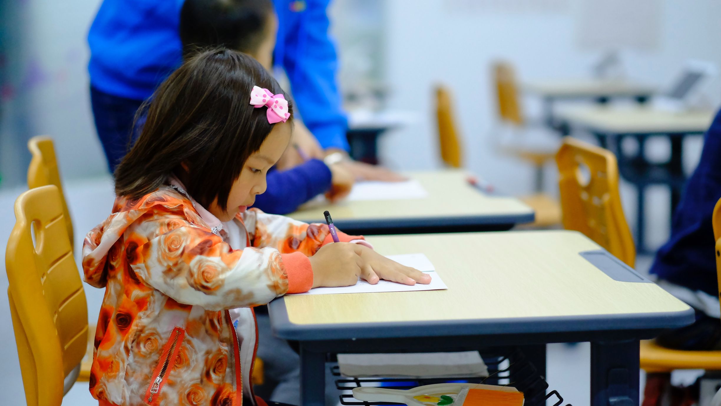 Young girl working at school desk-- Hazel Health